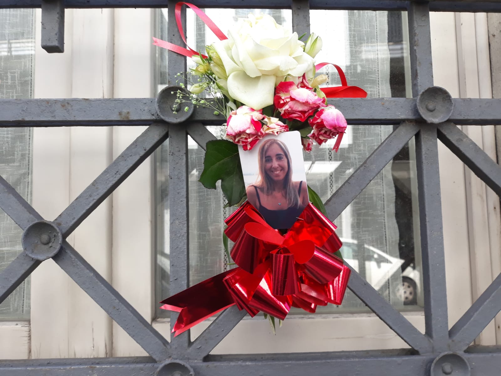 L'immagine di Manuela Bailo, con un fiore e un fiocco rosso contro i femminicidi, sulla finestra della sede Uil di via Vantini, a Brescia